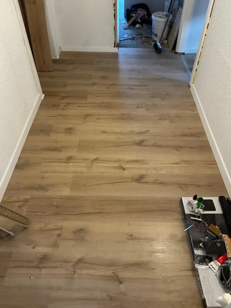 Flur mit frisch verlegtem Boden in Holzoptik während der Arbeiten