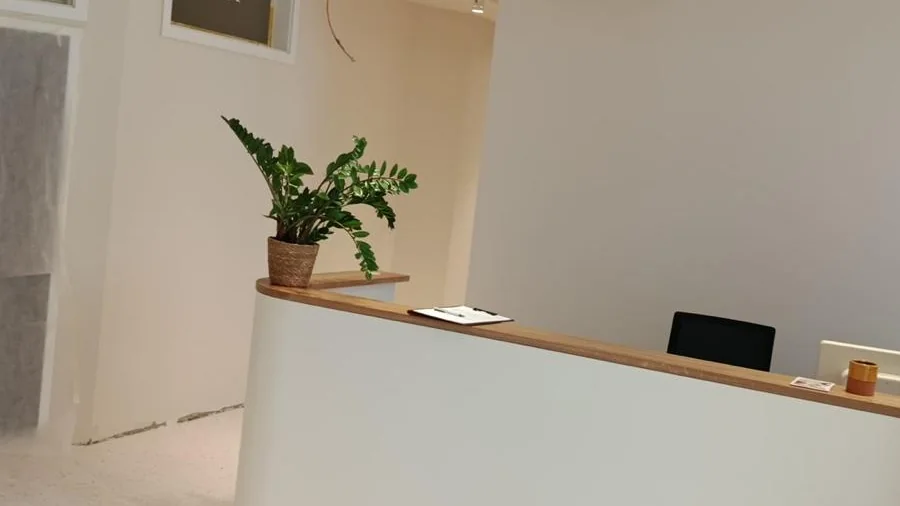 Fertig ausgebaute Gewerbefläche mit Empfangstheke und hellen Trockenbauwänden