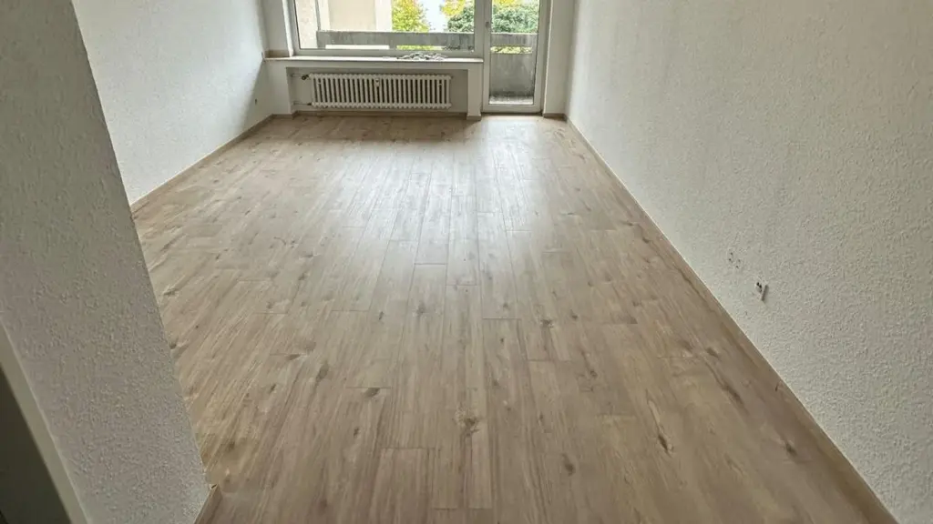 Leere, sanierte Wohnung mit neuem Boden und hellen Wänden