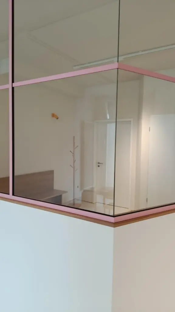 Trennwand mit großem Glasausschnitt in einem ausgebauten Raum