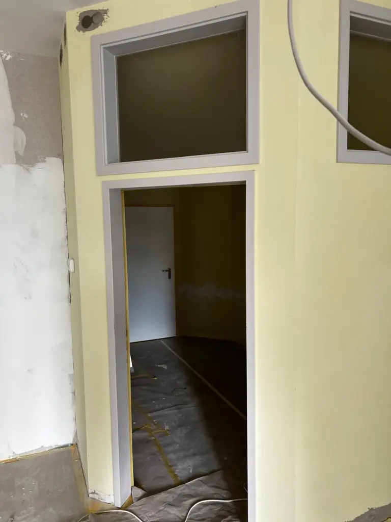 Trockenbauwand mit Türöffnung und Oberlichtern während des Ausbaus